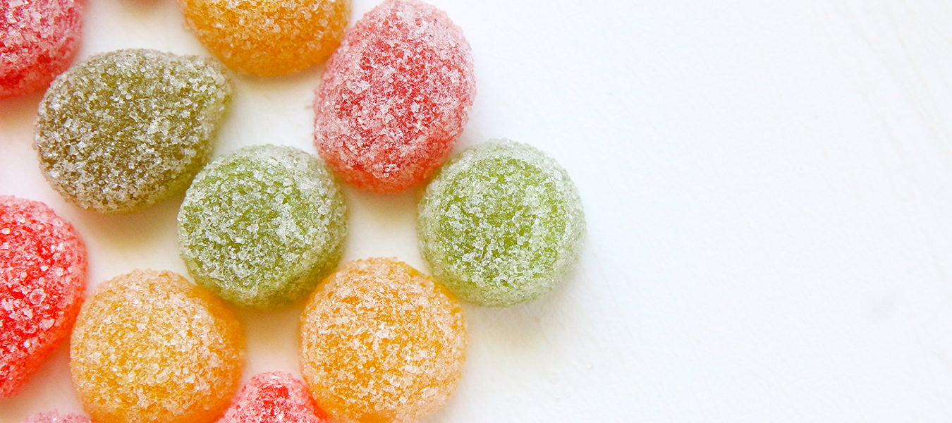 colorful candies on white backdrop - why too much sugar is bad